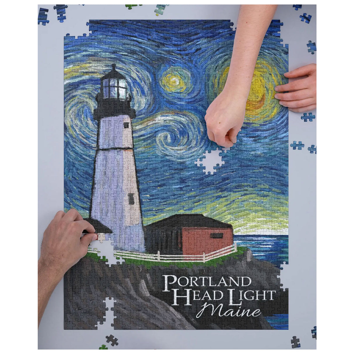 1000pc Portland Head Light Puzzle showing hands assembling a lighthouse with swirling night sky and ocean background.
