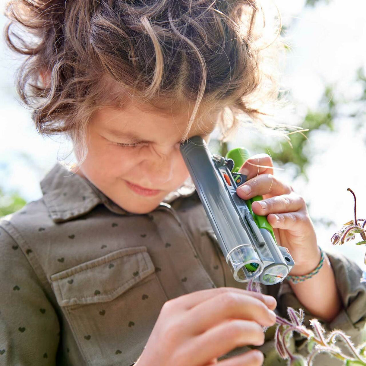 Child using the Terra Kids | Field Microscope outdoors to closely examine a plant with 30X magnification for junior explorers.