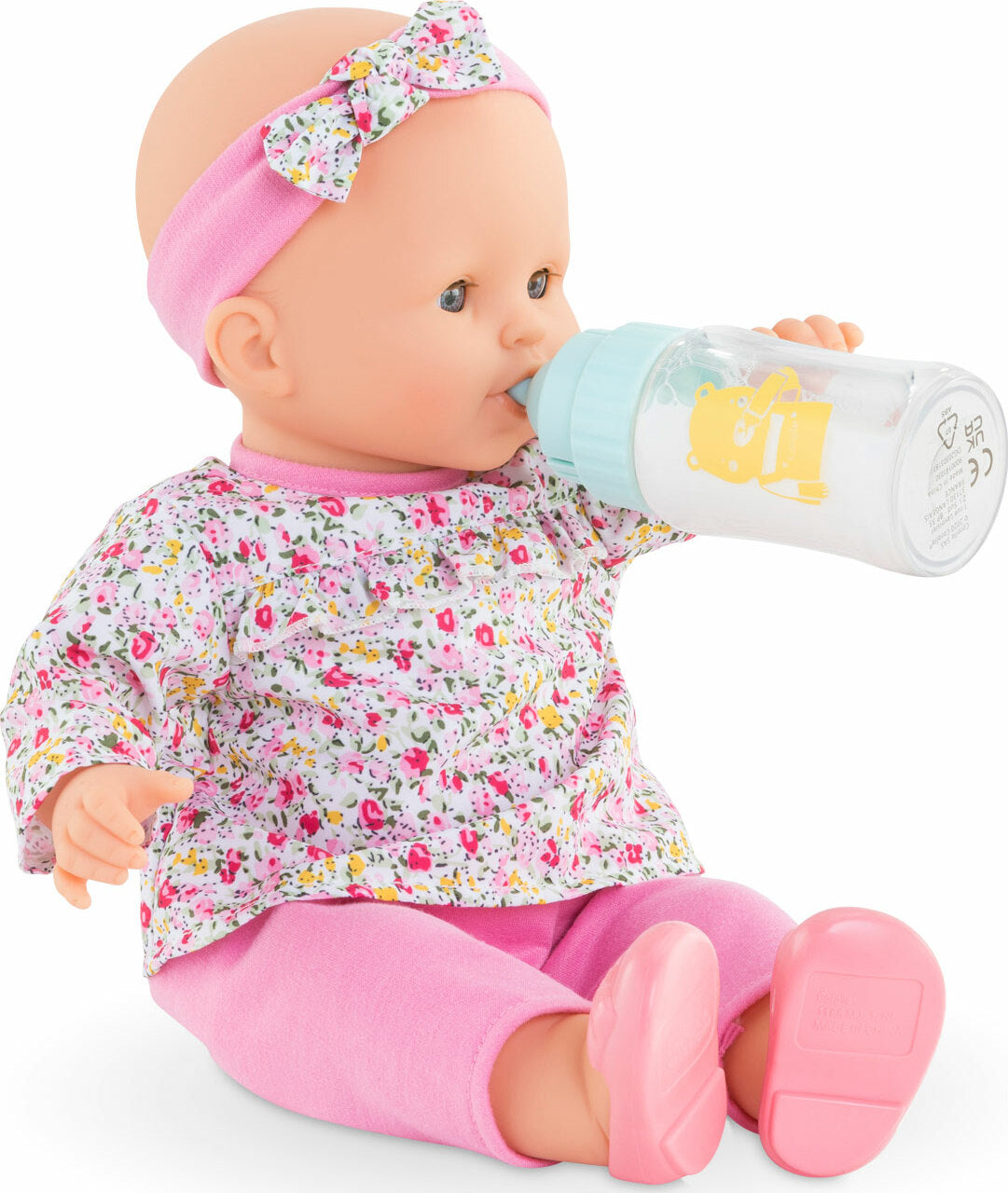 Baby doll wearing floral outfit and pink headband feeding with Magic Bottle with Sounds toy bottle.
