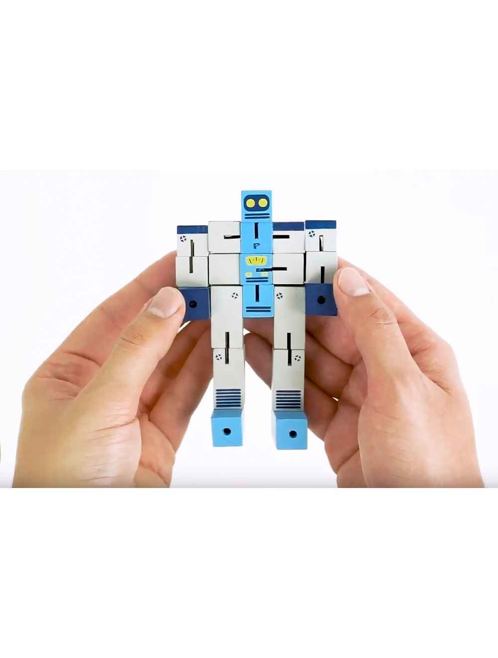 Hands holding Puzzle Planet Robot wooden brainteaser toy in robot form against white background