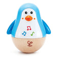 Musical Penguin Wobbler toy with blue wings, wooden base, and colorful musical notes for children aged 6+ months.