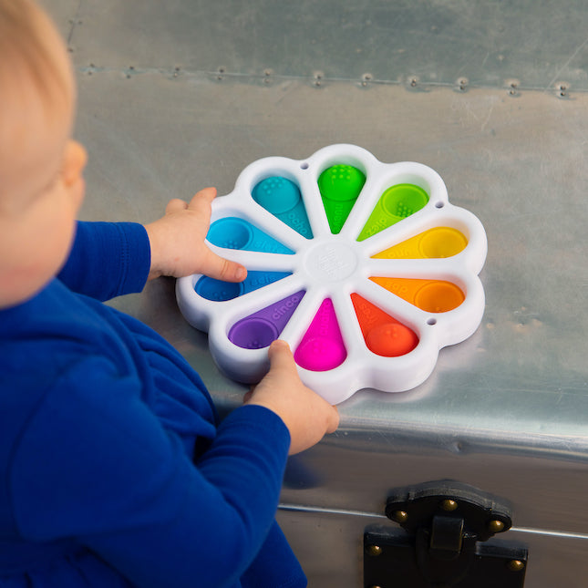Child playing with colorful, tactile silicone bubbles on Dimpl Digits, a fun educational toy for learning numbers.