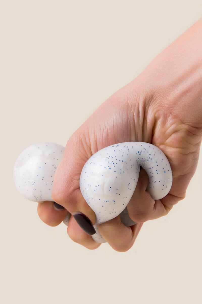 Hand squeezing the NeeDoh Snow Ball, a crunchy stress ball that feels like crunching through fresh snow.