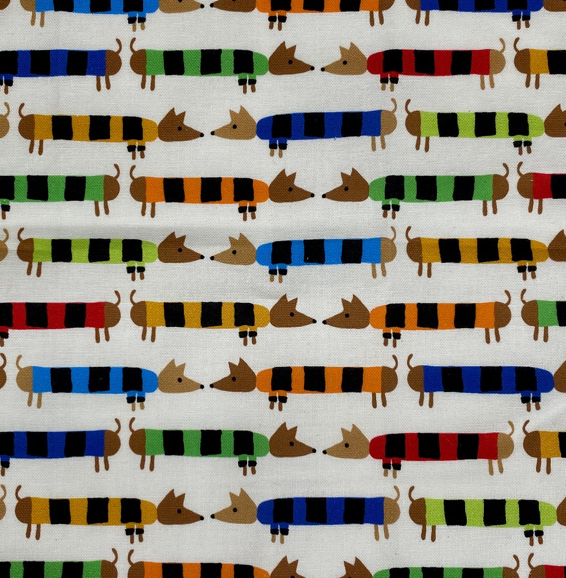 Baby Paper | Organic Dachshunds fabric featuring colorful striped dachshund pattern on a white background.