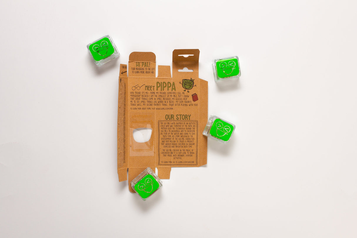Glo Pals Green light-up cubes around the open packaging showing four bright green glowing pals.