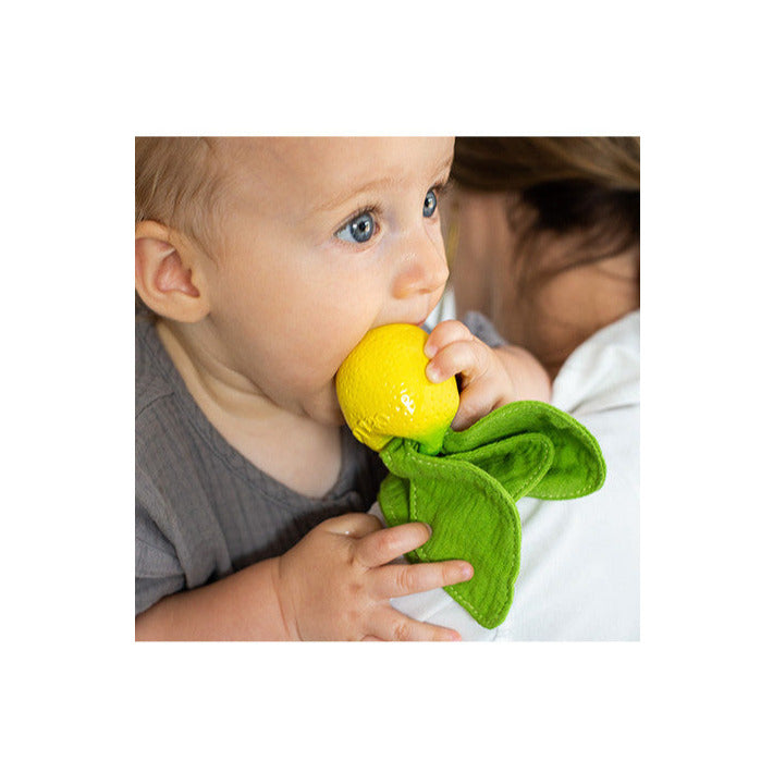 Baby chewing on a yellow teether with green muslin leaves, showcasing the Mini DouDou Teether | John Lemon for soothing gums.