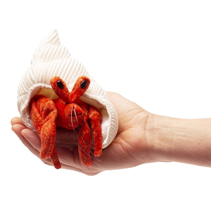 Hermit Crab Finger Puppet held in hand with textured white shell and bright orange crab body for interactive play.