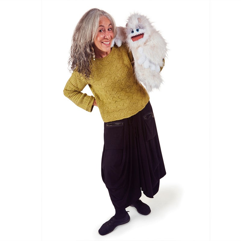 Woman smiling and posing with the playful snowy white Yeti Puppet with movable eyebrows and mouth for storytelling fun.