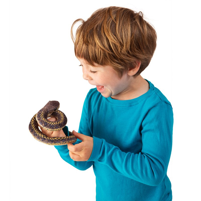 Young child smiling and playing with the coiled Snake Finger Puppet for nature exploration and fun.