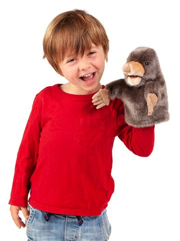 Boy smiling while playing with the Mole Little Hand Puppet featuring a large snout, movable mouth, and digging claws.
