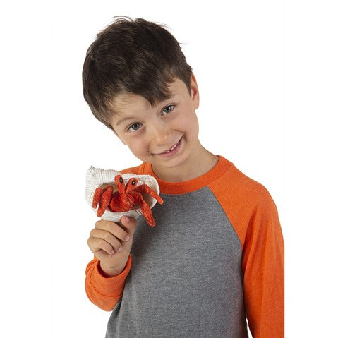 Child smiling and playing with textured shell and fabric Hermit Crab Finger Puppet on hand for interactive fun