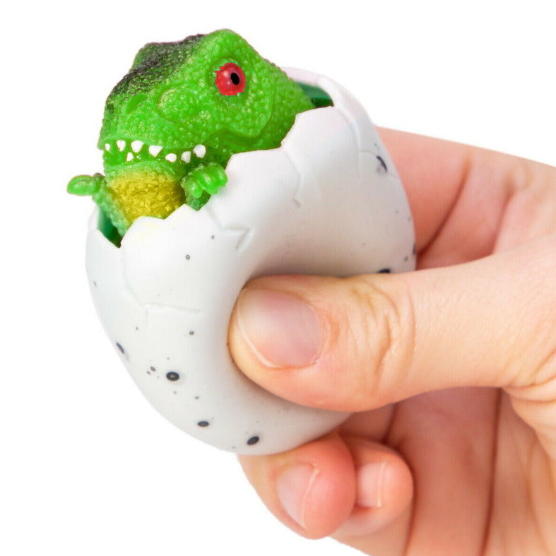 Squeezy Peek Hatcher Dino fragile egg cracked open with green dinosaur popping out held in hand toy for kids.