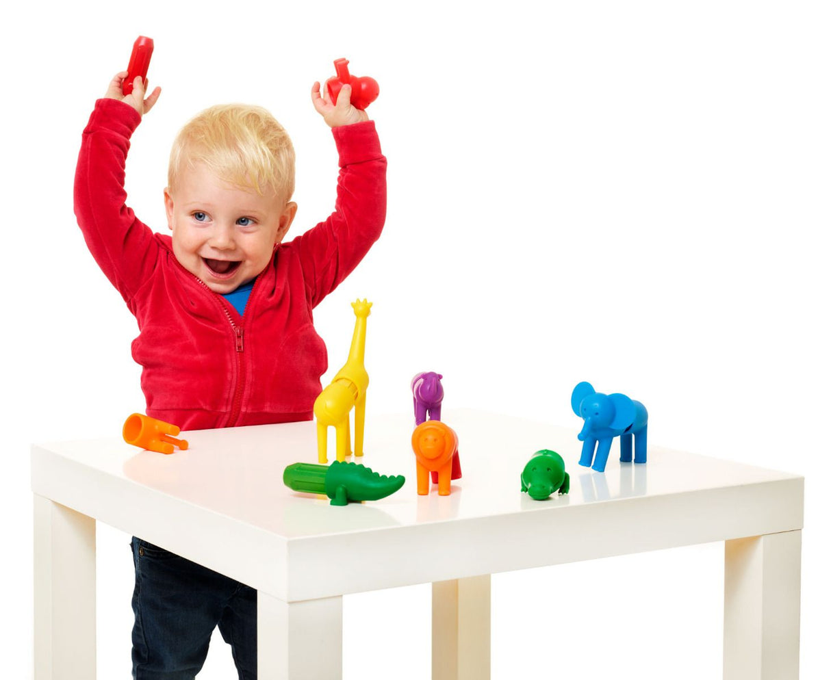 Happy toddler playing with colorful animal figures from Smartmax My First Safari Animals set on white table