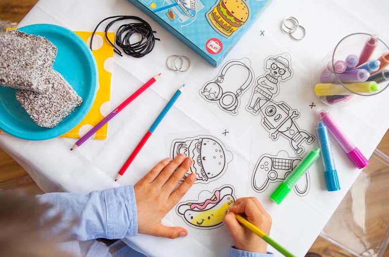 Shrinkies | Ultimate Collection showing a child coloring plastic charms before shrinking for jewelry and key chains.