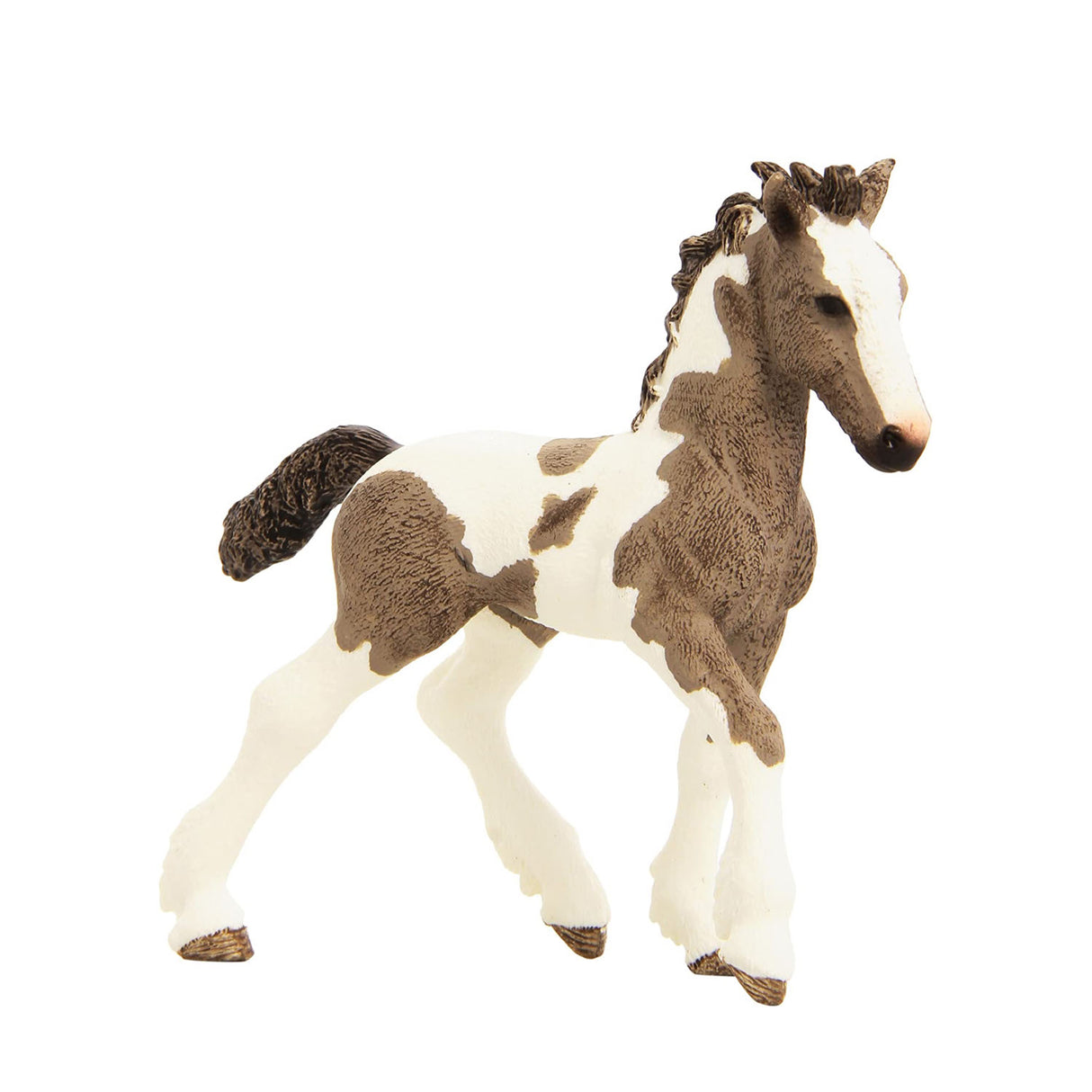 Tinker Horse Foal figurine with piebald coat, detailed mane, tail, and feathered fetlocks standing on white background.