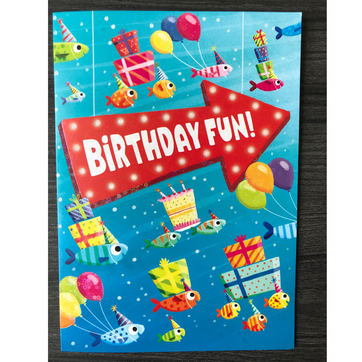 Fish Present Foil Card featuring colorful fish carrying balloons and gifts with a large Birthday Fun arrow on blue background.