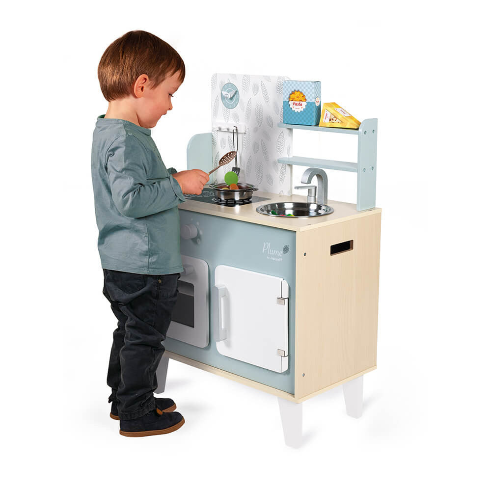 Child playing with Plume Kitchen Cooker wooden play kitchen set in blues and greys with accessories and induction hob.