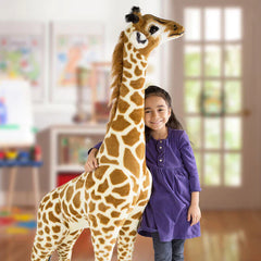 Smiling child standing beside a tall plush giraffe in a bright playroom