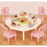 Sweets Party Set with pink chairs tea cups plates and colorful pastries on a table