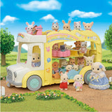 Yellow triple-decker nursery bus with animal toys seated inside and outside on a sunny day in a grassy area