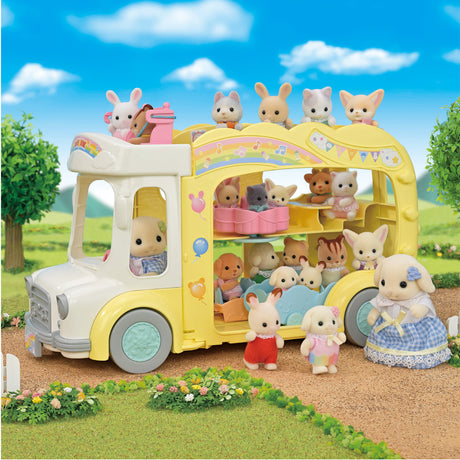 Yellow triple-decker nursery bus with animal toys seated inside and outside on a sunny day in a grassy area