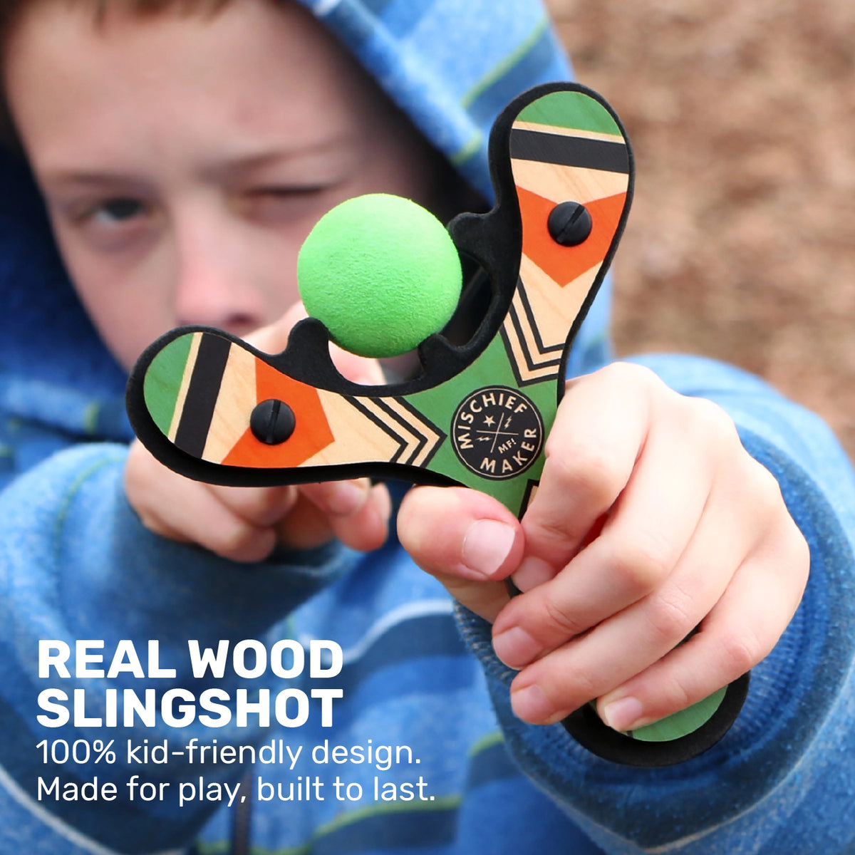 Slingshot Green wooden slingshot held by a child with a green ball