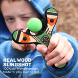 Slingshot Green wooden slingshot held by a child with a green ball