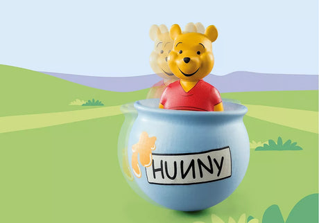 123 Winnie's Wobbly Honey Pot featuring Winnie the Pooh figure playfully wobbling in a blue honeypot toy.