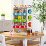 Wooden toy vending machine with colorful pretend snacks and drinks displayed on a round table in a bright room