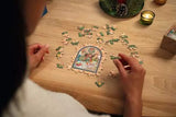 Puzzle Advent Calendar 2026 with a person assembling a festive jigsaw puzzle at a table