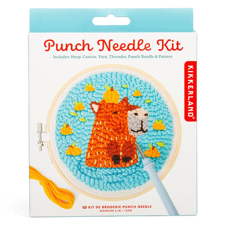 Punch needle kit with hoop and yarn creating an orange llama face with yellow flowers on blue fabric background
