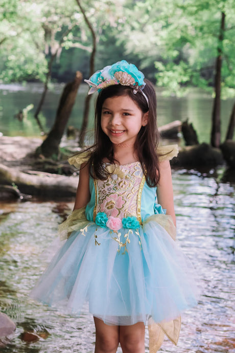 Young girl wearing the Mermalicious Dress with Tail featuring gold brocade, pastel flowers, and a shimmery blue skirt.