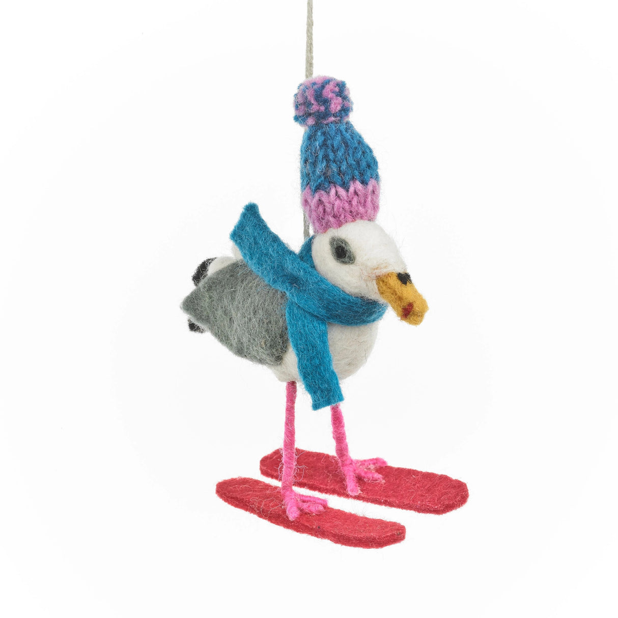 Felt seagull ornament wearing a blue hat and scarf, standing on red skis for holiday decoration