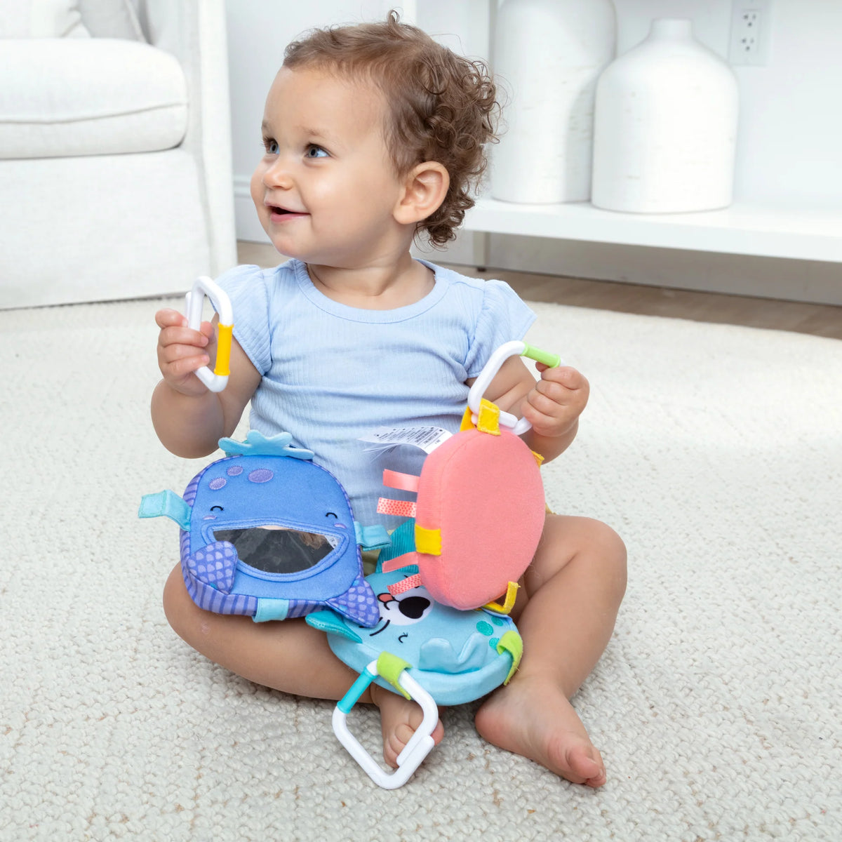 Ocean Waves Bounce Back Links colorful sensory toy with a happy toddler playing on the floor