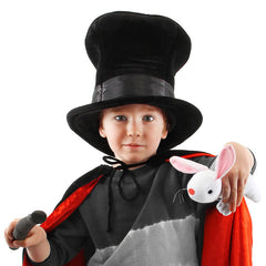 Child in a magician costume holding a white rabbit puppet while wearing a top hat and red cape