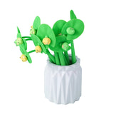 White vase filled with green lotus leaf pens featuring cute frog shaped wiggle toppers