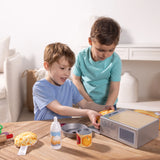 Two young boys playing with a pretend pie making set and fabric pie crust on a wooden table indoors