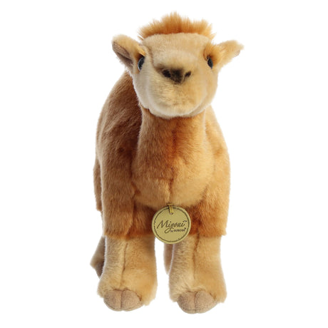 Plush dromedary camel with soft sandy fur, signature hump, and embroidered details, standing against a white background.