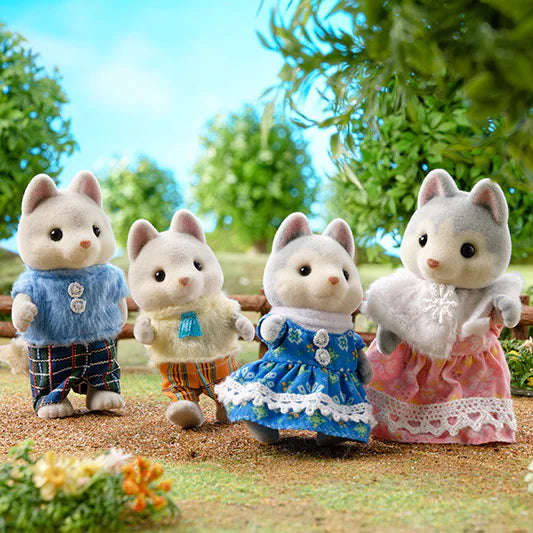 Husky Family plush cat figures in colorful outfits posed outdoors<|end|>