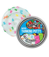 Shimmery white putty with colorful bear-shaped pieces beside a metal tin labeled Mini Thinking Putty Gummy Grizzly