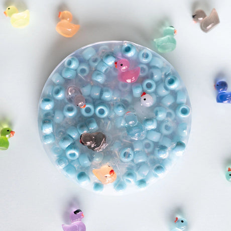 Clear gelatinous ball with small toys on a white background