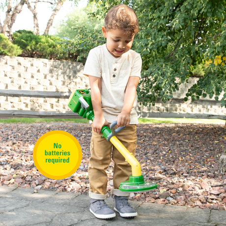 Child playing outdoors with the John Deere Weed Trimmer toy, no batteries required and kid powered fun.