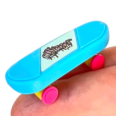 Japanese Eraser Skateboard in blue with pink wheels held on a hand, eco-friendly puzzle eraser with rolling wheels.
