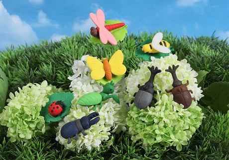 Japanese Eraser Insect showing colorful bug-shaped erasers placed on green and white flower clusters outdoors.