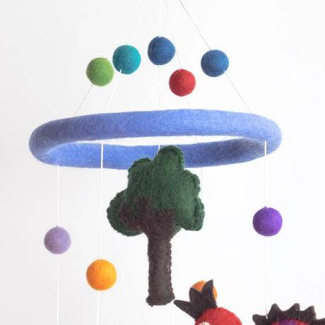 Felt Mobile | Dinosaur with colorful felt balls and tree hanging from a soft blue wool ring mobile.