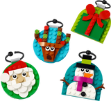 Colorful building block ornaments shaped like Santa, reindeer, snowman, and a gift with a bow on round bases