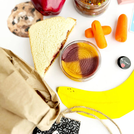 KidDough | Peanut Butter Jelly Time sensory dough with peanut butter and grape jelly colors displayed with lunch items.