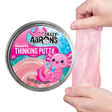 Shimmering pink Amazing Axolotl Thinking Putty being stretched beside its colorful tin packaging with playful axolotl design.