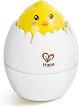 Yellow chick toy peeking out of white egg shell designed to engage babies and develop motor skills