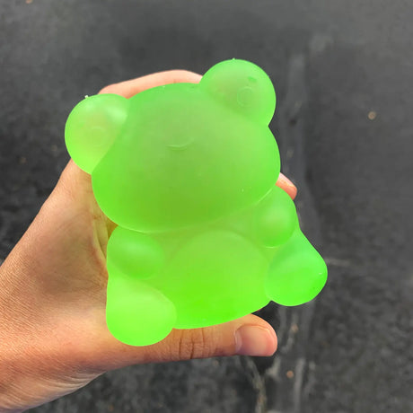 Hand holding a bright green Super Duper Sugar Squisher Frog with a soft, squishy texture for hours of fun.